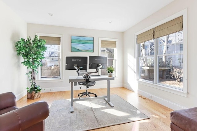 office with baseboards, visible vents, and wood finished floors