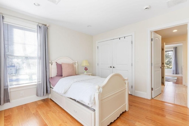 bedroom featuring baseboards, visible vents, light wood-type flooring, a closet, and recessed lighting