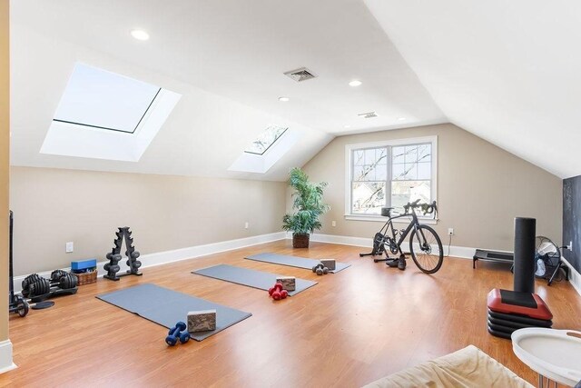 workout room featuring lofted ceiling, recessed lighting, wood finished floors, visible vents, and baseboards