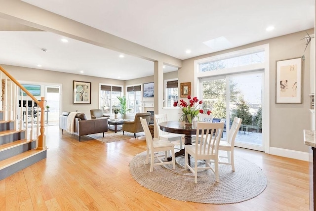 dining room with light wood-type flooring, baseboards, stairway, and recessed lighting