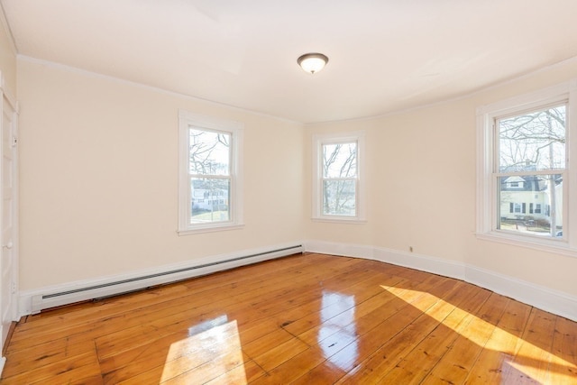 empty room featuring light wood-type flooring and a baseboard heating unit