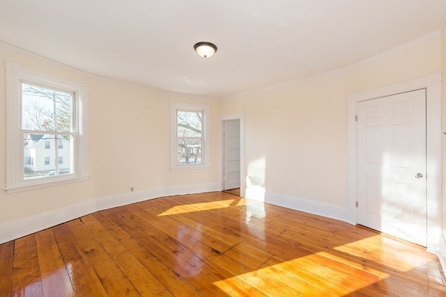 empty room with ornamental molding and light wood-type flooring