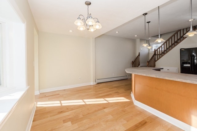 kitchen featuring decorative light fixtures, an inviting chandelier, a baseboard radiator, light hardwood / wood-style flooring, and black fridge with ice dispenser