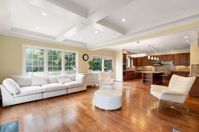 living room with hardwood / wood-style flooring, beamed ceiling, crown molding, and a wealth of natural light