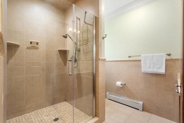 full bathroom with a baseboard radiator, tile walls, ornamental molding, a shower stall, and tile patterned floors