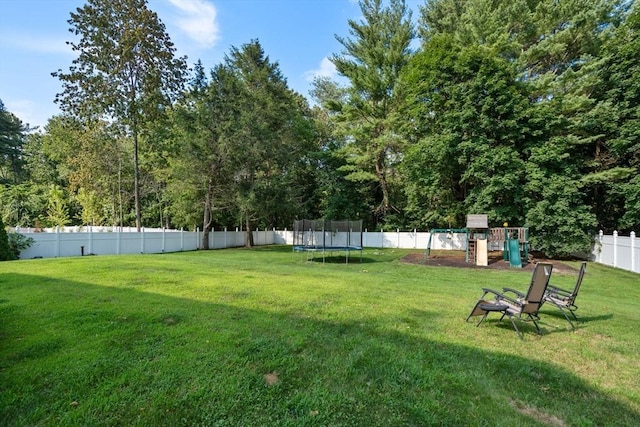 view of yard featuring a fenced backyard, a trampoline, and a playground