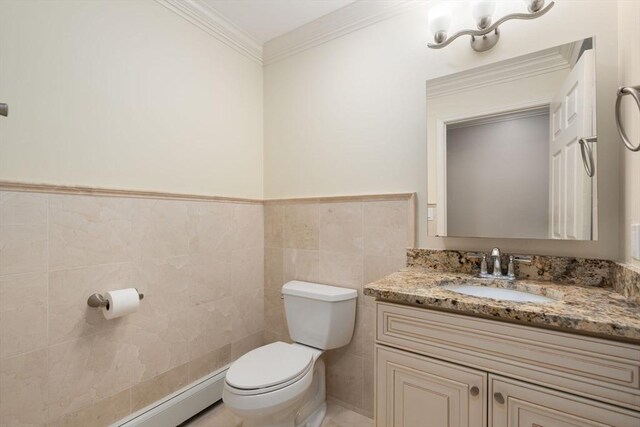 bathroom with tile walls, crown molding, vanity, and toilet