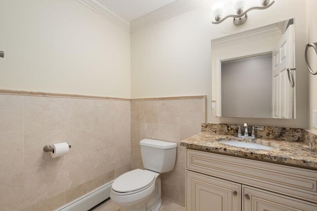 bathroom with toilet, ornamental molding, vanity, a baseboard heating unit, and tile walls