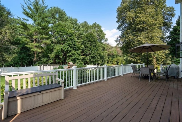 wooden terrace featuring fence, a playground, and outdoor dining space