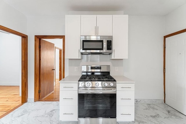 339-341 Norfolk St, Cambridge, MA 02139 - kitchen featuring stainless steel appliances, light marble finish flooring, light countertops, and white cabinets