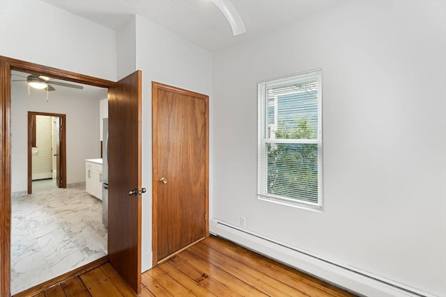 339-341 Norfolk St, Cambridge, MA 02139 - unfurnished bedroom featuring baseboard heating, light marble finish floors, a ceiling fan, and a closet