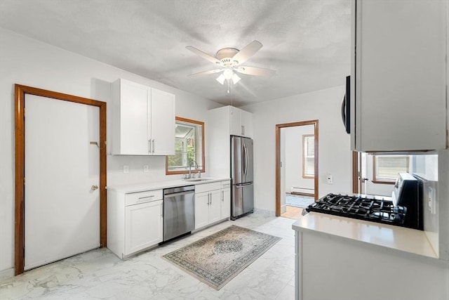 339-341 Norfolk St, Cambridge, MA 02139 - kitchen featuring appliances with stainless steel finishes, a sink, light marble finish floors, a ceiling fan, and white cabinets