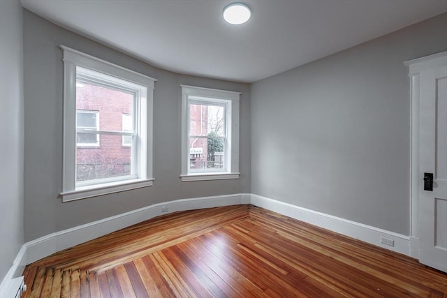 spare room with a baseboard radiator and hardwood / wood-style flooring