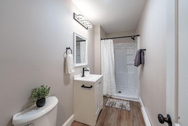 bathroom with vanity, toilet, curtained shower, and wood-type flooring