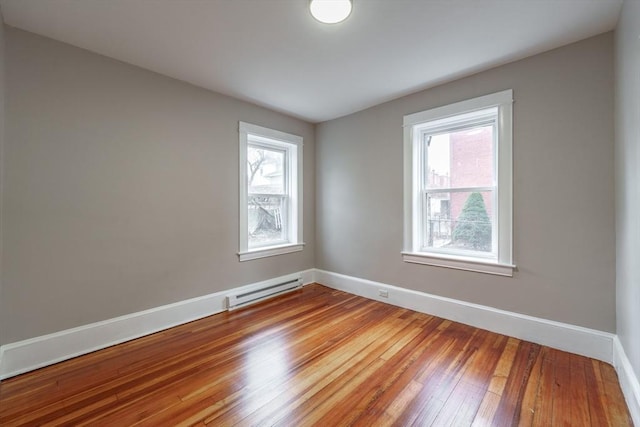 spare room with a baseboard radiator and wood-type flooring