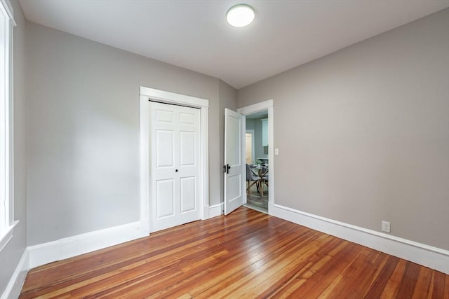 unfurnished bedroom with a closet and hardwood / wood-style flooring