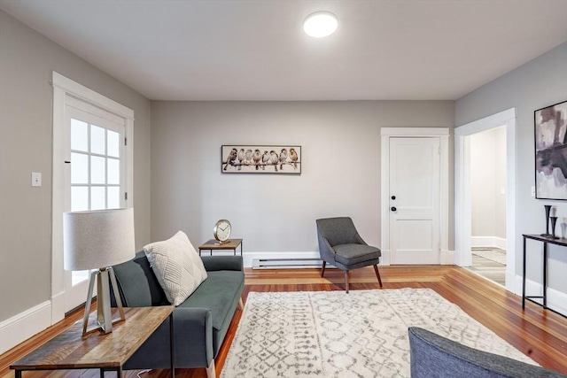 living room with baseboard heating and wood-type flooring