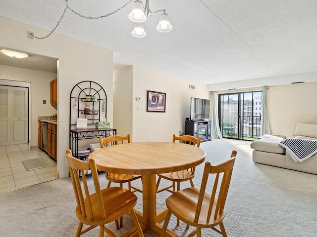 dining space with light carpet and a chandelier