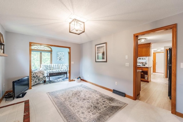 35 Dejordy Ln, Chicopee, MA 01020 - unfurnished room featuring light carpet, baseboards, a textured ceiling, and a chandelier