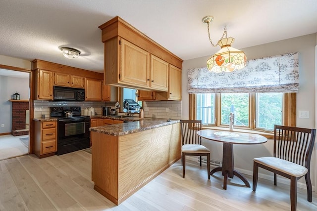 35 Dejordy Ln, Chicopee, MA 01020 - kitchen with black appliances, a peninsula, light wood-style flooring, and healthy amount of natural light