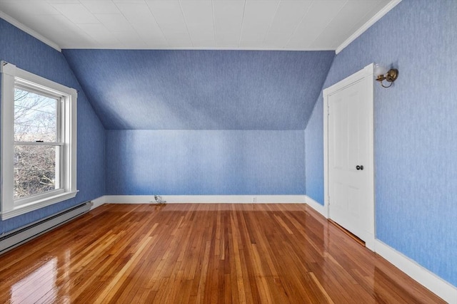 additional living space with a baseboard heating unit, lofted ceiling, and hardwood / wood-style floors