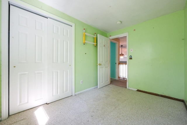 unfurnished bedroom featuring carpet flooring, a closet, and baseboards