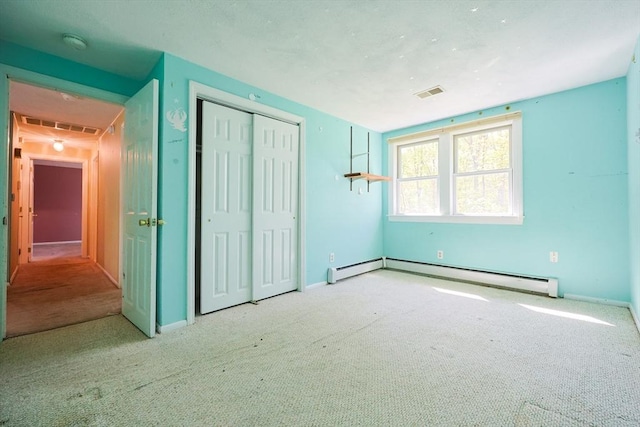 unfurnished bedroom with a baseboard radiator, carpet flooring, a closet, and baseboards