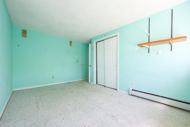 carpeted spare room with baseboard heating and baseboards