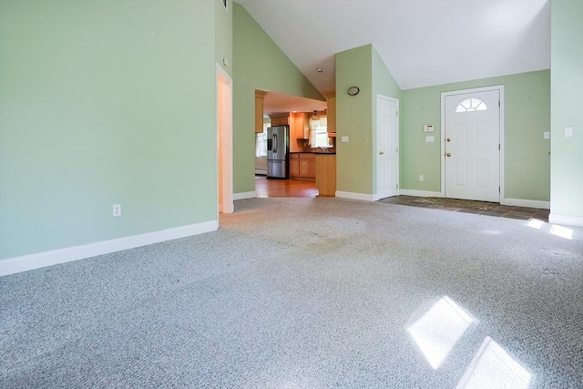 unfurnished living room with carpet floors, lofted ceiling, and baseboards