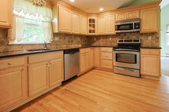 kitchen featuring appliances with stainless steel finishes, a sink, light brown cabinets, light wood-style flooring, and recessed lighting
