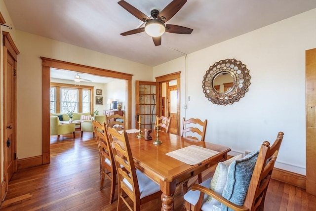 dining room featuring wood-type flooring, baseboards, and a ceiling fan