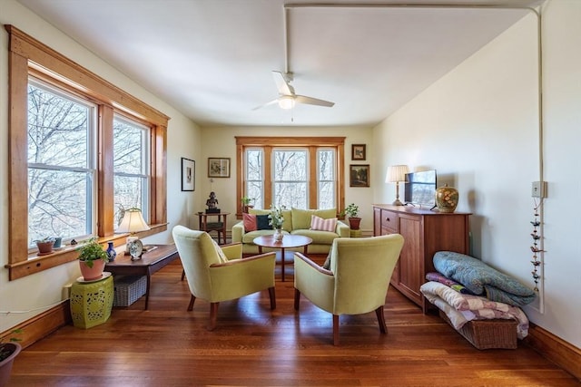 sitting room with ceiling fan, wood finished floors, and baseboards