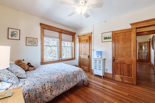 bedroom featuring a ceiling fan, baseboards, and wood finished floors