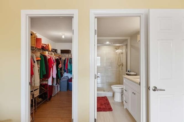 200 Ledgewood Dr Unit 604, Stoneham, MA 02180 - bathroom with vanity, wood finished floors, a stall shower, and a spacious closet