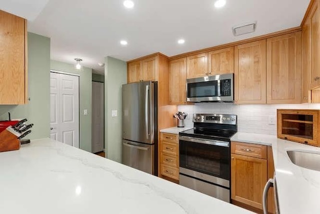 200 Ledgewood Dr Unit 604, Stoneham, MA 02180 - kitchen featuring appliances with stainless steel finishes, light stone counters, tasteful backsplash, and recessed lighting