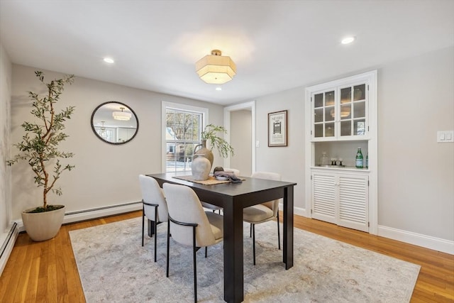 dining area featuring light hardwood / wood-style flooring and a baseboard radiator