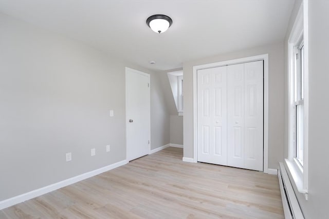 7 Dewey Ave, East Longmeadow, MA 01028 - unfurnished bedroom with a baseboard heating unit, light wood-style flooring, and a closet