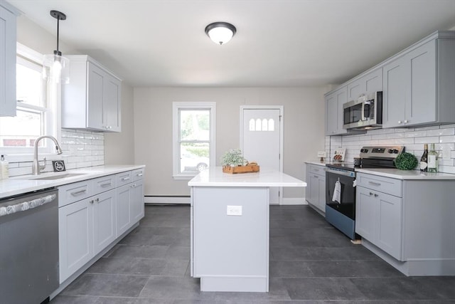 7 Dewey Ave, East Longmeadow, MA 01028 - kitchen with appliances with stainless steel finishes, a kitchen island, tasteful backsplash, a baseboard radiator, and light countertops
