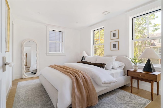 13 Mellen St, Cambridge, MA 02138 - bedroom featuring multiple windows, light wood-type flooring, and baseboards
