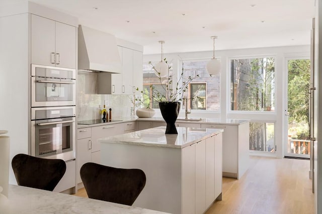 13 Mellen St, Cambridge, MA 02138 - kitchen featuring custom range hood, a center island, stainless steel double oven, backsplash, and a sink