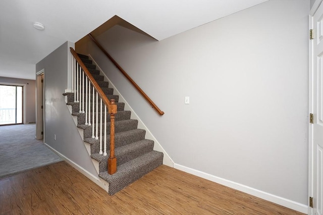 stairs with baseboards and wood finished floors