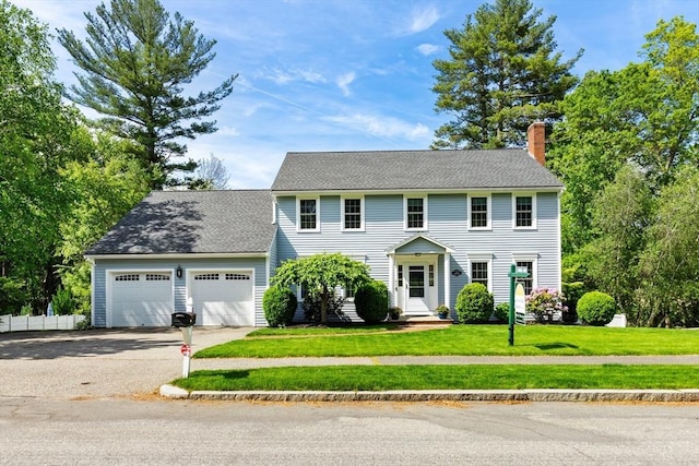 51 Lilah Ln, Reading, MA 01867 - colonial inspired home with a chimney, an attached garage, asphalt driveway, and roof with shingles