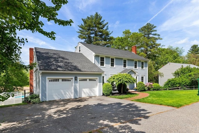 51 Lilah Ln, Reading, MA 01867 - colonial home featuring a chimney, driveway, and a shingled roof
