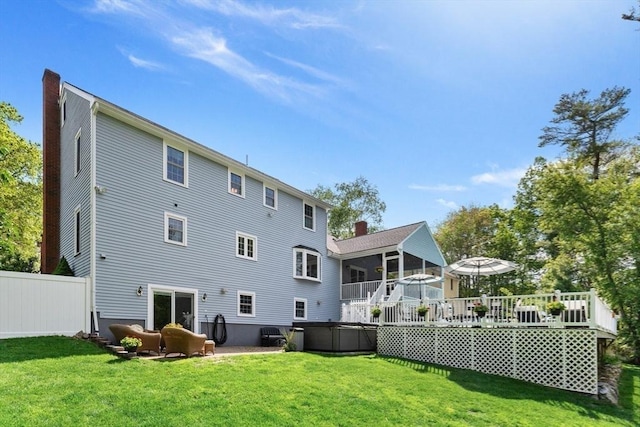 51 Lilah Ln, Reading, MA 01867 - back of property with a sunroom, a hot tub, a wooden deck, and a chimney