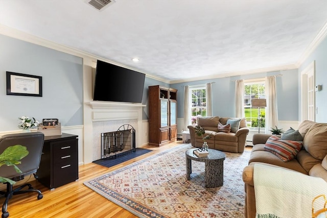51 Lilah Ln, Reading, MA 01867 - living room featuring ornamental molding, a fireplace with flush hearth, light wood-style flooring, a desk, and a wainscoted wall