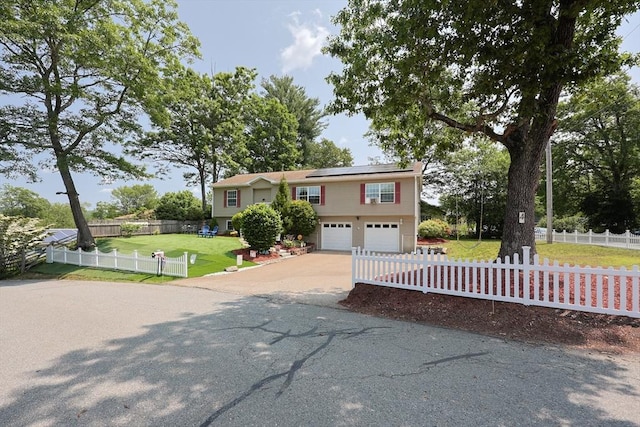4 Colonial Rd, Webster, MA 01570 - raised ranch featuring a front lawn, driveway, solar panels, and a garage