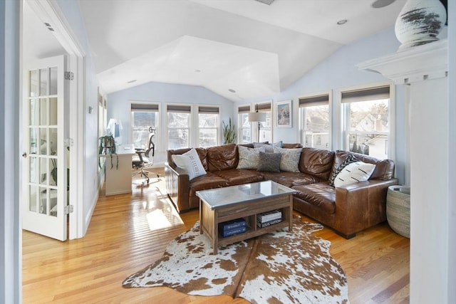 living room featuring light hardwood / wood-style flooring and vaulted ceiling