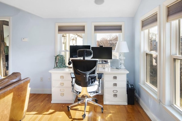 office space with light hardwood / wood-style flooring, a healthy amount of sunlight, and lofted ceiling