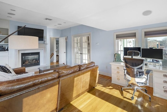 living room with french doors and light wood-type flooring