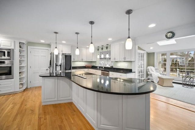 kitchen featuring appliances with stainless steel finishes, dark countertops, white cabinets, and a sink